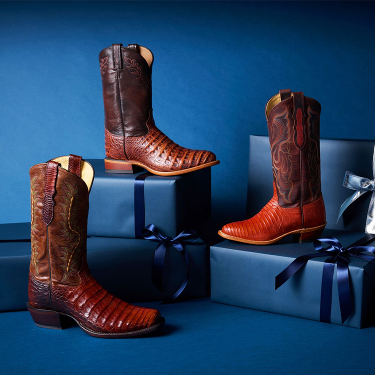 Three single boots from the Limited Edition Collection sitting on a pile of navy-wrapped gifts.